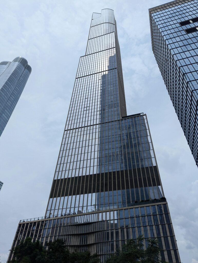 Home Tall modern skyscraper with reflective glass in a bustling urban environment.